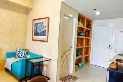 a living room with a blue couch and a table at Twin Oaks Place West Tower in Manila