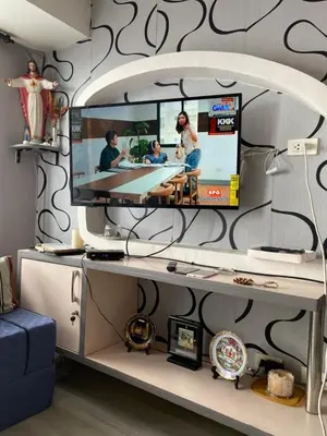 a living room with a tv on a wall at Casa Maria in Manila