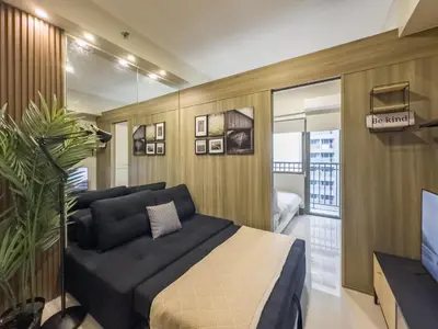 a bedroom with a bed and a tv in it at GemstoneBR in SMDC Fame Residences in Manila