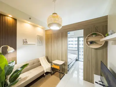 a living room with a couch and a bed at GemstoneBR in SMDC Fame Residences in Manila