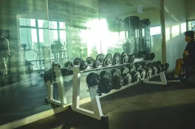 a row of dumbbells in a gym with a mirror at Stylish 1BR Near US Embassy & Luneta with Pool & Gym in Manila
