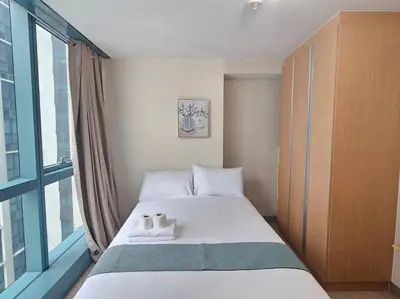 a bedroom with a bed with two towels on it at One Uptown Executive 2 bedroom, with balcony, washer & Netflix in Manila