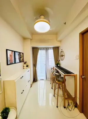 a room with a kitchen with a desk and a table at Minimalist and Serene 1BR Condo Unit near MOA in Manila