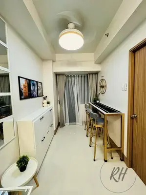 a living room with a piano and a table and chairs at Minimalist and Serene 1BR Condo Unit near MOA in Manila