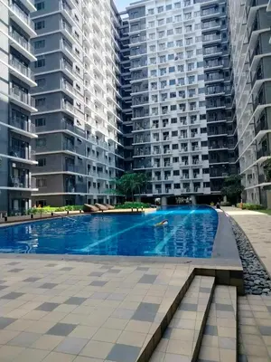 a swimming pool in front of two tall buildings at Comfy 42 shore 3 Residence Free parking, Near Airport, IKEA, MOA, Pasay City in Manila