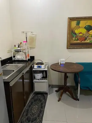 a kitchen with a table and a sink and a table at Hungary109 Service Apartments Near Airport at Kassel Residences in Manila