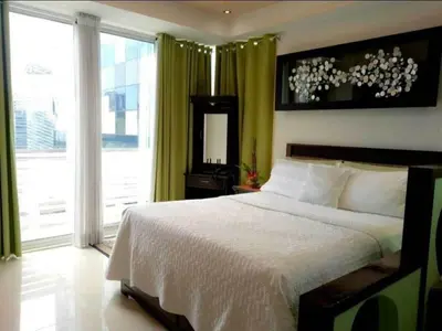 a bedroom with a bed and a large window at Executive Studio Apartment in BGC in Manila