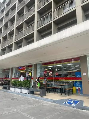 a large building with tables and benches in front of it at Shore Residences Tower D - One Bedroom I Good for 6 guests I Walk to Mall of Asia in Manila