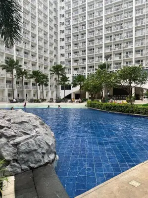 a large apartment building with a large swimming pool at Shore Residences Tower D - One Bedroom I Good for 6 guests I Walk to Mall of Asia in Manila