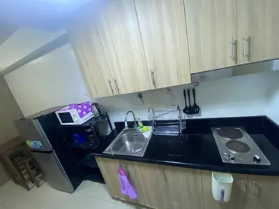 a small kitchen with a sink and a microwave at Shore2 Condo 1BR Balcony, Wifi, Pool, MOA, Airport in Manila