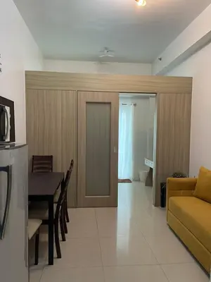a living room with a couch and a table at Shore Residence Direct Pool Access MOA Complex in Manila