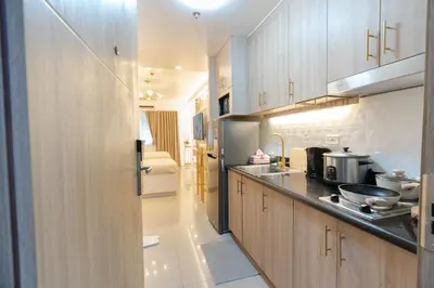 a kitchen with wooden cabinets and a sink at Modern Living 4 MOA Pasay in Manila