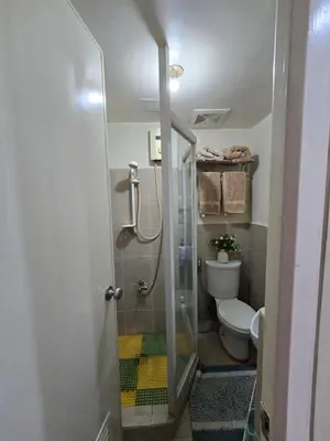 a bathroom with a shower and a toilet at Cozy apartment near Greenbelt Makati City in Manila