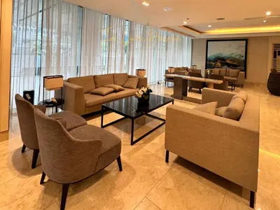 a living room with couches and chairs and a table at The Luxe Haven Shore 3 Residences in Manila