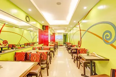 a restaurant with tables and chairs and a clock on the wall at Townhouse OAK Makati Manila Near PNR Pasay Evangelista formerly VIP Suites in Manila