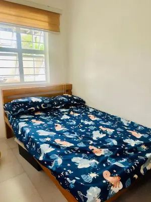 a bedroom with a bed with a blue comforter with cows at Tinyhaven Transient Cabuyao in Cabuyao
