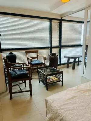 a living room with chairs and tables and a bed at Spacious 1BR steps to Megamall Ortigas City View in Manila