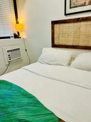 a bedroom with a bed and an air conditioner at Spacious 1BR steps to Megamall Ortigas City View in Manila