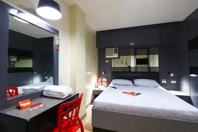 a bedroom with a bed and a table and a desk at Hotel Sogo - Pasay Rotonda in Manila