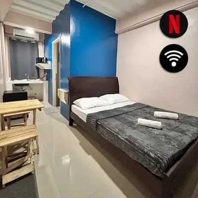 a bedroom with a large bed with a letter k on the wall at Origin Studios - Walk to Highstreet, BGC in Manila