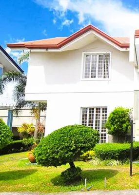 a white house with a tree in front of it at USO House in Manggahan