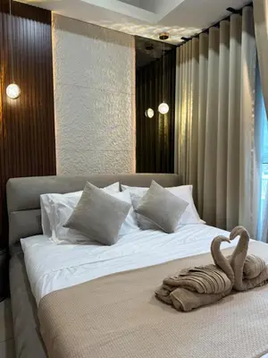 a bedroom with a large bed with a towel on it at Stylish 1BR Near Airport Facing the Bay - 7b in Manila