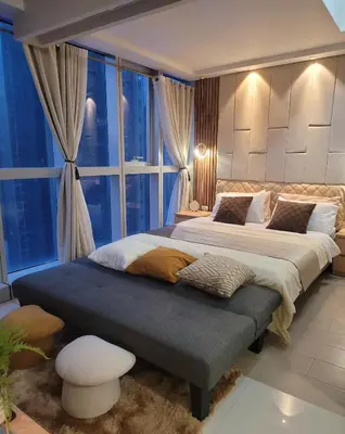 a bedroom with two beds and a large window at Staycations Up Above 13 at BGC in Manila