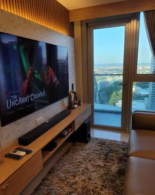 a living room with a large flat screen tv at Uptown Parksuites Tower 2 BGC - Staycations Up Above 9 in Manila