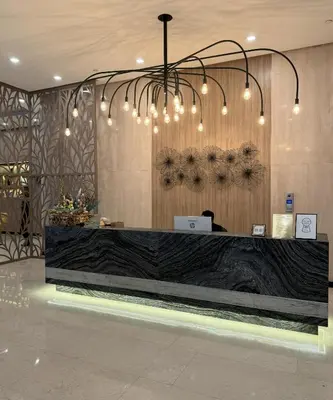 a lobby with a reception desk with a chandelier at One Uptown Residences at BGC - Staycations Up Above 15 in Manila
