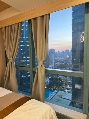 a bedroom with a window with a view of a city at One Uptown Residences at BGC - Staycations Up Above 15 in Manila
