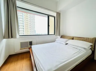 a bed in a room with a large window at Budget Family Room at Ace Suites by the Famous Indoor Water Spa in Manila