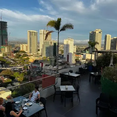 a view of a city from a restaurant with tables at Budget Family Room at Ace Suites by the Famous Indoor Water Spa in Manila