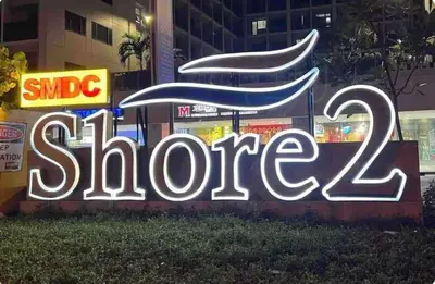 a neon sign that says slore in front of a building at Nordic Style - 2BR Shore 2 Residences Tower 2 in Manila