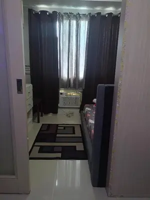 a room with black curtains and a room with rugs at Reynas place at sea residences in Manila