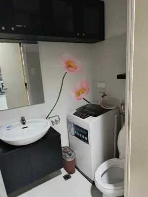 a bathroom with a sink and a toilet with flowers on the wall at Mall of Asia Sea Residences Staycation Pasay City in Manila