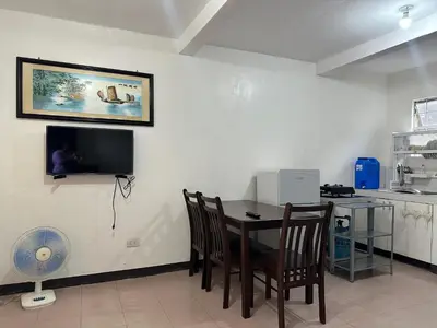 a dining room with a table and a tv on the wall at 2 StoryHome in Tanza near SM along Main Road in Tanza