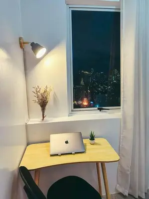 a laptop computer sitting on a table next to a window at Condo unit in Manda near Edsa, Shangrila, Megamall in Manila