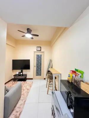 a living room with a couch and a flat screen tv at Casa Luz Budget Condotel in Manila