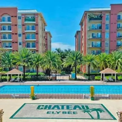 a large swimming pool with palm trees and buildings at Casa Luz Budget Condotel in Manila
