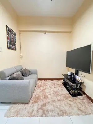 a living room with a couch and a flat screen tv at Casa Luz Budget Condotel in Manila