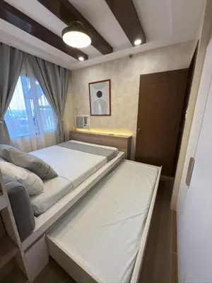 a bedroom with two beds and a window at Mi Casa en Manila in Manila