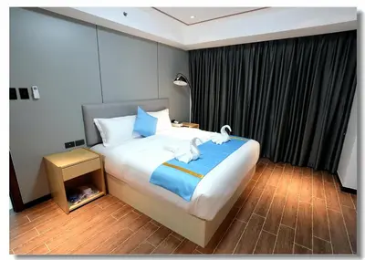 a bedroom with a large bed with blue and white pillows at Golden Seagulls Hotel in Manila