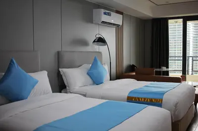 two beds in a hotel room with blue pillows at Golden Seagulls Hotel in Manila