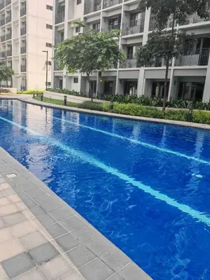 a blue swimming pool in front of a building at Zeki's Place - Shore 2 Residences MOA in Manila