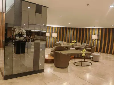 a lobby with couches and tables in a building at Zeki's Place - Shore 2 Residences MOA in Manila
