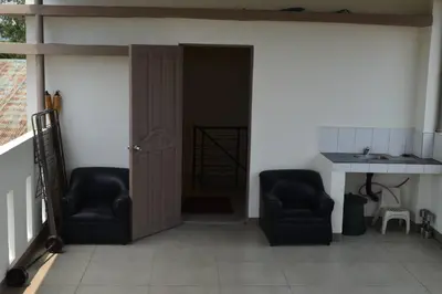 two chairs in a living room with a door at Home in Pasig in Manila