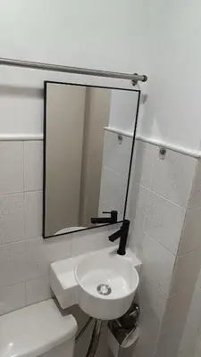a white bathroom with a mirror and a sink at Home in Pasig in Manila