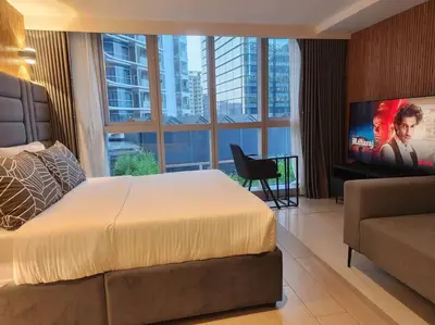 a hotel room with a bed and a flat screen tv at BGC Cosy Hotel Vibe Uptown Parksuites Studio in Manila