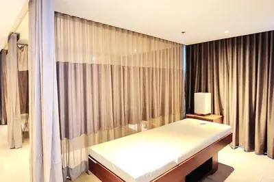 a bedroom with a bed and a window with curtains at BGC Cosy Hotel Vibe Uptown Parksuites Studio in Manila