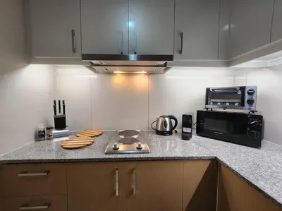 a kitchen with a counter top with a microwave at BGC Cosy Hotel Vibe Uptown Parksuites Studio in Manila